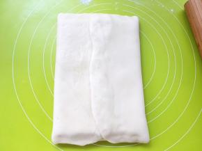 之后将两侧的面片对折，包裹上黄油，捏紧收口