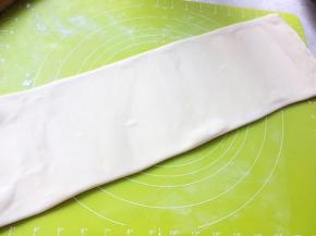 撒点干粉，将面片擀长，长度50厘米左右，正好是揉面垫斜角的长度