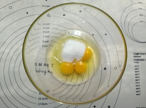 鸡蛋和糖用手动打蛋器打匀。