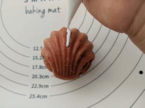 用白巧克力做奥特曼的装饰。如果有彩色的巧克力就更方便了。如果没有就像我一样用白色巧克力然后涂上色素吧。