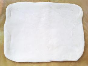 冰箱取出冷冻的面片，揉面垫上撒点干粉，将面片移到揉面垫上