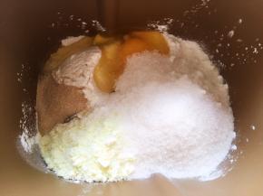 面包桶内加入高筋面粉，低筋面粉，奶粉，全蛋液，细砂糖跟酵母，加冰牛奶启动揉面程序将材料揉成面团