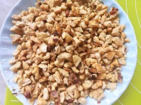 出炉取出核桃仁，烤过的核桃仁轻轻搓一下就可以去掉表皮，之后将核桃仁压碎备用