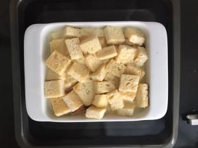 将烤碗装进装水的烤盘中，水量要超过烤碗一半以上