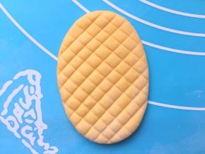 取一个面团擀成椭圆形，用刮板压出玉米的颗粒纹路