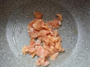 腌渍好的鸡腿肉入油锅翻炒。