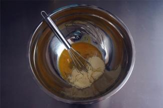 将糖粉和奶粉的混合物加入到蛋液中，搅拌均匀。