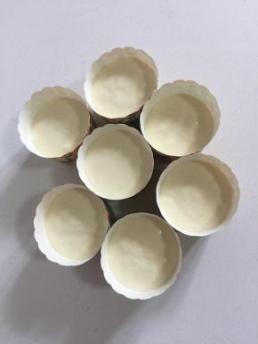 拌好的蛋糊倒进纸杯中（不要倒的太满，八分满即可。）把纸杯使劲儿在案板上震几下，震出里面的气泡儿。