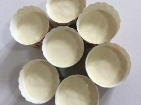 拌好的蛋糊倒进纸杯中（不要倒的太满，八分满即可。）把纸杯使劲儿在案板上震几下，震出里面的气泡儿。