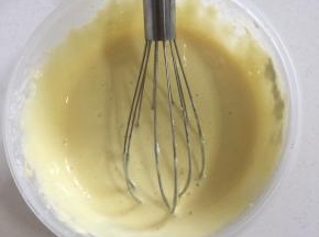 挖三分之一的蛋白到面糊中。用打蛋器上下左右不规则的翻拌均匀！