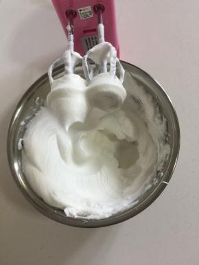 蛋白里面加入2滴白醋和白糖30克，用电动打蛋器先高速打发蛋白，感到蛋白有厚重感了改为中速打发蛋白，直到打到像图片上这样蛋白打发到有坚挺的小尖角了，再改为低速打发几下，整理一下蛋白里面的气泡。（打发蛋白的时候可以把烤箱预热着！）
