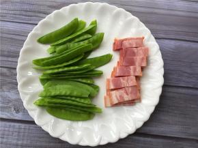 将荷兰豆洗净去筋，培根切小块备用。