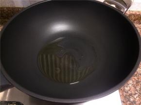 热锅倒油烧至八成热。