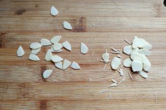 再取适量杏仁片，用食品剪刀修剪出三角形形状当作猫咪的耳朵。