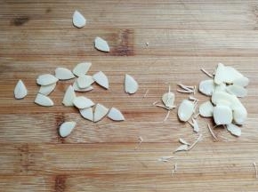 再取适量杏仁片，用食品剪刀修剪出三角形形状当作猫咪的耳朵。