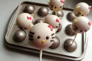 巧克力凝固晾干后，先融化一点可可巧克力装入裱花袋挤上猫咪的眼睛和胡须，然后再取适量剩下的白巧克力，分别调入少许食用色素挤上猫咪的蝴蝶结和小嘴巴，这样可爱的猫咪棒棒糖蛋糕就完成了。