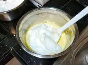 将打发好的蛋白3分之一倒入奶酪糊中搅拌均匀