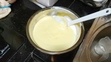 再将搅拌均匀好的奶酪糊全部倒入剩余蛋清里搅拌均匀