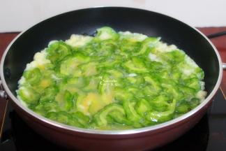 热锅，倒油，遵守热锅冷油的原理。火调制中火，倒入苦瓜鸡蛋液入锅，鸡蛋颜色变白，有凝固的时候，翻炒一下。