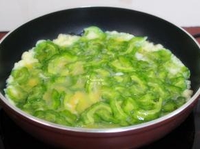 热锅，倒油，遵守热锅冷油的原理。火调制中火，倒入苦瓜鸡蛋液入锅，鸡蛋颜色变白，有凝固的时候，翻炒一下。