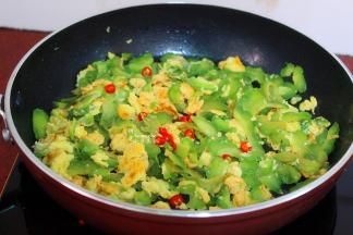 这个时候可以加入红辣椒，增加味道，还能使得苦瓜不苦哦，炒至蛋熟，苦瓜也熟，关火，放入切好的葱，炒均即可。