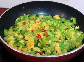 这个时候可以加入红辣椒，增加味道，还能使得苦瓜不苦哦，炒至蛋熟，苦瓜也熟，关火，放入切好的葱，炒均即可。