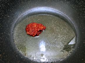 油温升高后加入剁碎的郫县豆瓣酱，小火慢慢翻炒出红油来