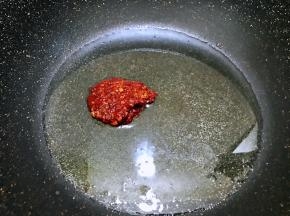 油温升高后加入剁碎的郫县豆瓣酱，小火慢慢翻炒出红油来