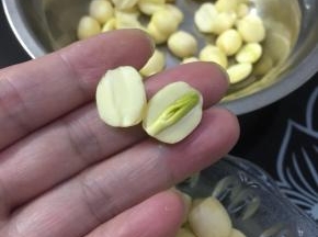 把莲子掰开取出莲心。（想要莲子完整的也可以用牙签把莲心顶出来。）