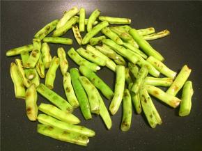 先热锅倒少量油将四季豆煸熟透，煸至表皮出焦点，然后盛出备用。