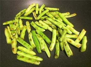 先热锅倒少量油将四季豆煸熟透，煸至表皮出焦点，然后盛出备用。