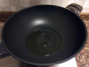 热锅倒油烧至八成热。