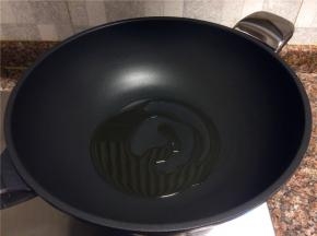 热锅倒油烧至八成热。