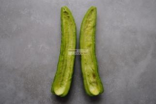 苦瓜洗净后切开两半，用勺子挖出中间的瓜瓢，尽量去掉白色部分，这个部分比较苦。