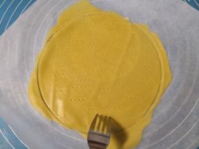 划好圆形之后，周围多余的面皮“不要”拿掉(多余的面皮跟着一起烤，一会还有用)， 用叉子在面皮上均匀的扎上眼儿(防止烤的时候鼓包) 