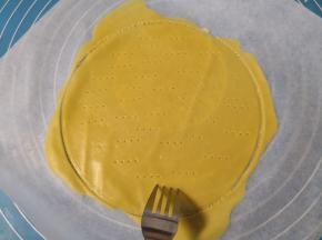 划好圆形之后，周围多余的面皮“不要”拿掉(多余的面皮跟着一起烤，一会还有用)， 用叉子在面皮上均匀的扎上眼儿(防止烤的时候鼓包) 