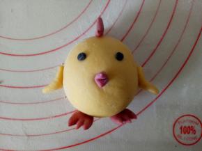 将小鸡的各个部件刷一点水粘起来，翅膀粘的时候折一下，这样好粘，用黑色面团做眼睛，嘴巴用牙签稍微压一下更显逼真。一只可耐的小鸡就做好了