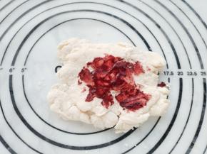 在静置好的面团中，分割出70克面团，将红曲糊加入面团中，尽量揉成颜色均匀的粉色面团。实在揉不匀也没关系，压面时颜色会变得很均匀。