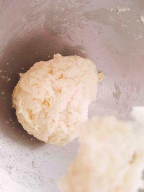 开动厨师机低速把面粉团成团，再启动中高速把面团揉至表面光滑