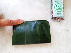 最后将底下的粽叶折上来，多余的可以包过去，或者用剪刀剪掉