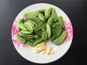 将扁豆洗净去筋，大蒜切片。