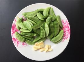 将扁豆洗净去筋，大蒜切片。