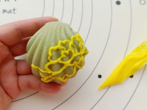 用黄色的奶油霜把牡丹花的轮廓画出来。
