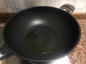 热锅倒油烧至八成热。