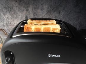 将吐司片插入到多士炉的吐司槽中，选择所需的烧色