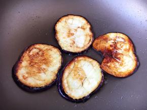 中火，放入茄子片，每片每面煎制约2分钟左右，把茄子的两面都煎至金黄色。