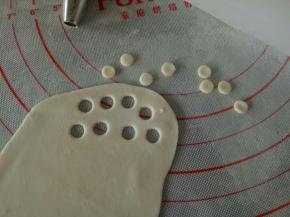 取适量白色面团擀薄，用圆形花嘴压出几个圆来，做小黄人的眼睛部分