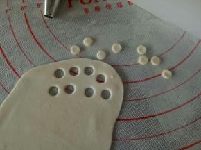 取适量白色面团擀薄，用圆形花嘴压出几个圆来，做小黄人的眼睛部分