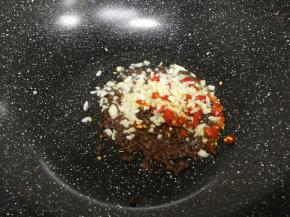 锅洗干净，放少许油，八分热倒入花椒，蒜泥和尖辣椒爆香