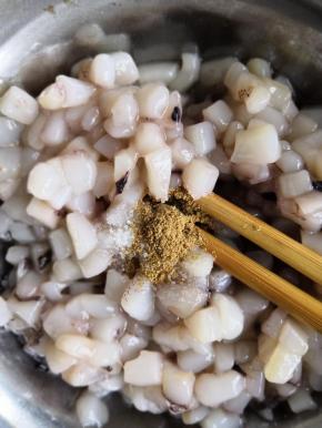 鱿鱼块儿加入适量的料酒、盐、十三香搅拌均匀腌制十五分钟